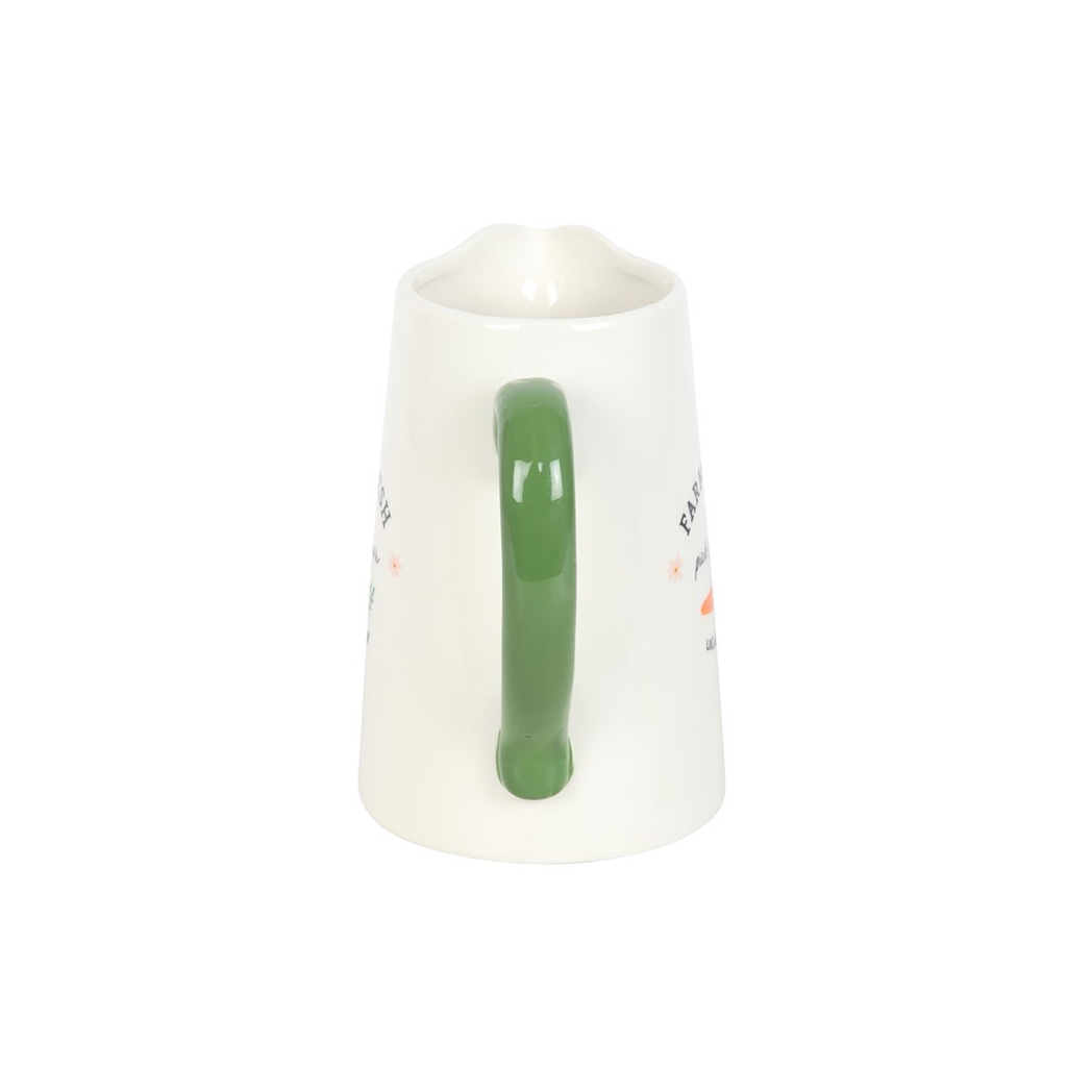 White jug with a green handle on a white background