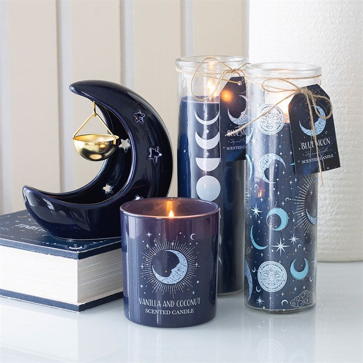 Decorative candles with moon and star designs on a white surface.
