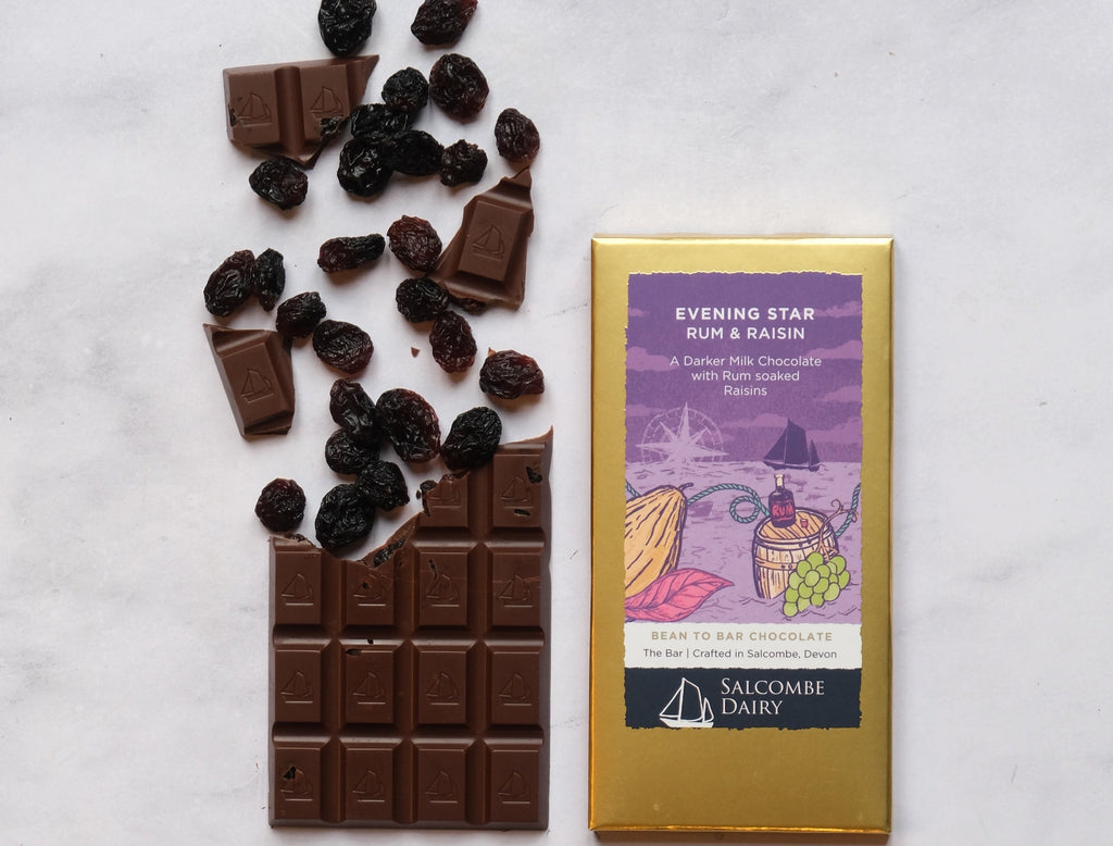 Chocolate bar with rum and raisins and its packaging on a light background