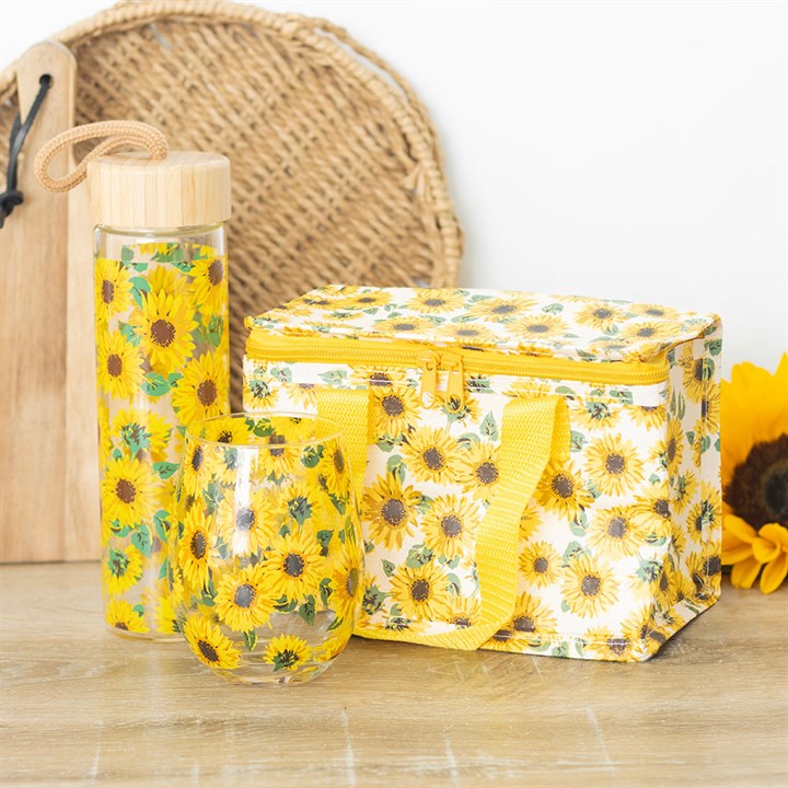 Sunflower-patterned water bottle and lunch bag on a wooden surface with a woven basket and sunflower in the background.