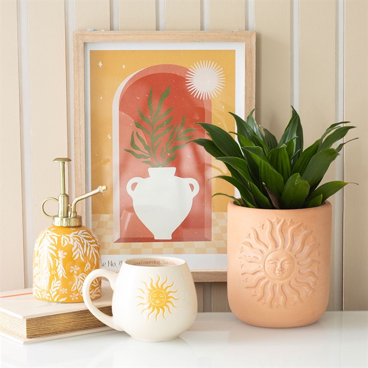 Decorative items including a spray bottle, plant pot, mug, and framed artwork on a shelf.