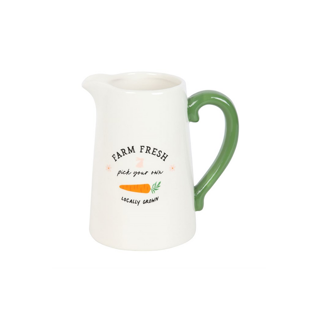 White ceramic pitcher with green handle and 'Farm Fresh' text on a white background